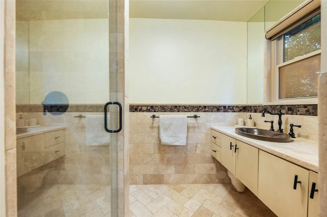 bathroom with vanity, an enclosed shower, and tile walls