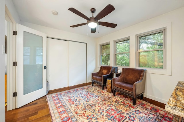 living area featuring dark hardwood / wood-style floors and ceiling fan