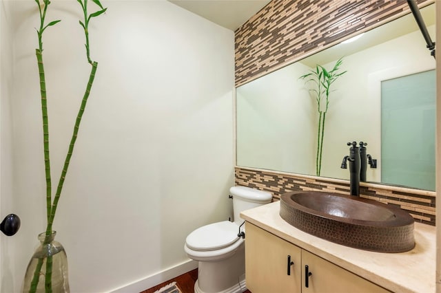 bathroom with vanity, toilet, backsplash, and hardwood / wood-style floors