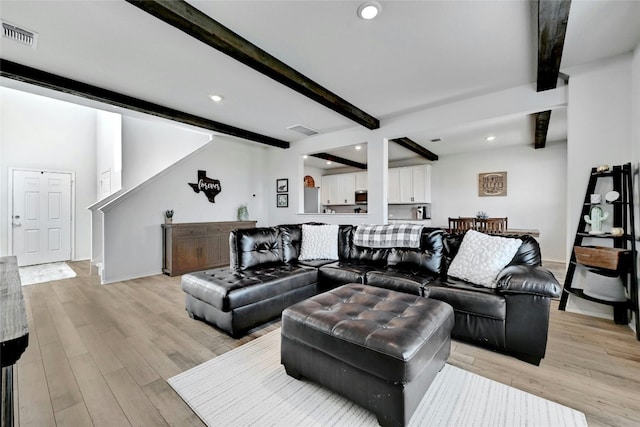 living room featuring light hardwood / wood-style floors and beam ceiling