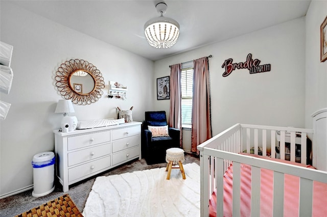 bedroom with a nursery area and dark colored carpet