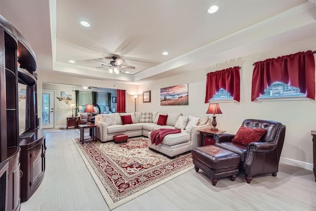 living room featuring a raised ceiling, ceiling fan, and hardwood / wood-style floors