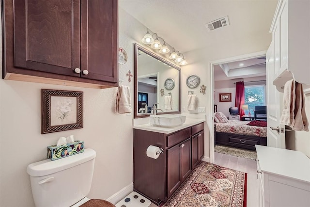 bathroom with vanity, toilet, and wood-type flooring