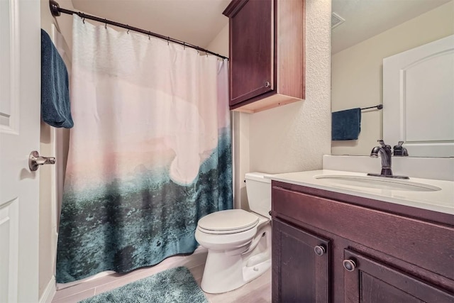 bathroom with tile patterned flooring, vanity, and toilet