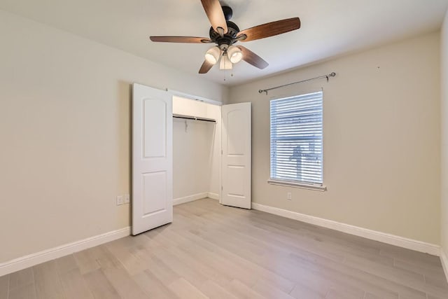 unfurnished bedroom featuring ceiling fan, light wood-type flooring, and a closet