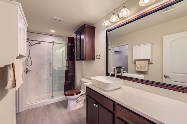 bathroom with vanity, hardwood / wood-style flooring, toilet, and a shower with shower door