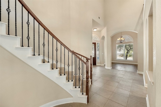 entrance foyer featuring a towering ceiling, an inviting chandelier, and light hardwood / wood-style flooring