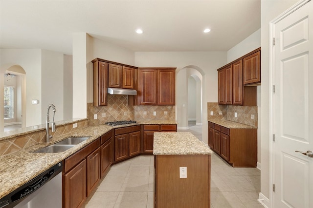 kitchen with appliances with stainless steel finishes, light stone countertops, sink, and light tile patterned floors