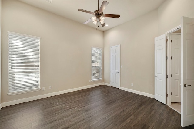 unfurnished bedroom with dark hardwood / wood-style flooring, multiple windows, and ceiling fan