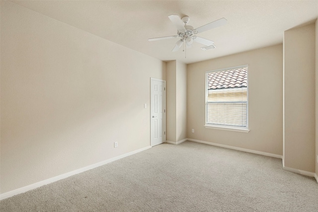 empty room with ceiling fan and light colored carpet