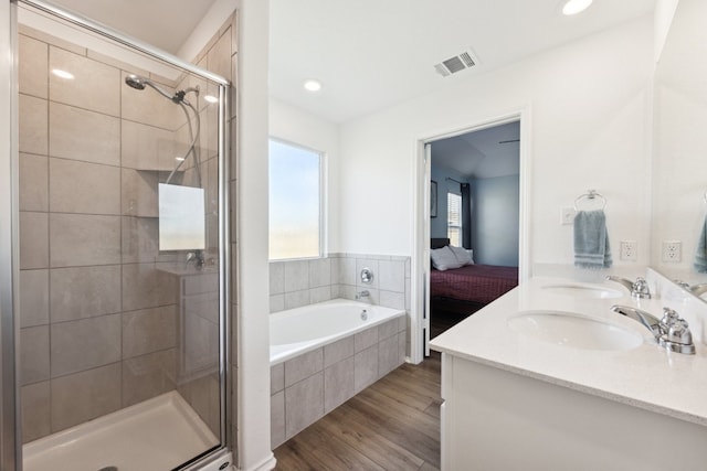 bathroom featuring vanity, hardwood / wood-style flooring, and shower with separate bathtub