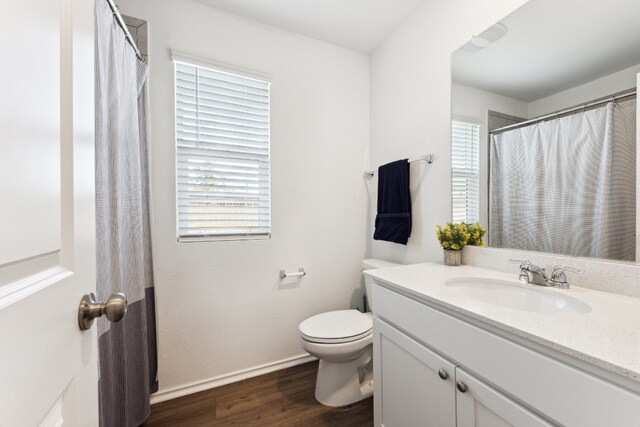 bathroom with vanity, toilet, and hardwood / wood-style flooring