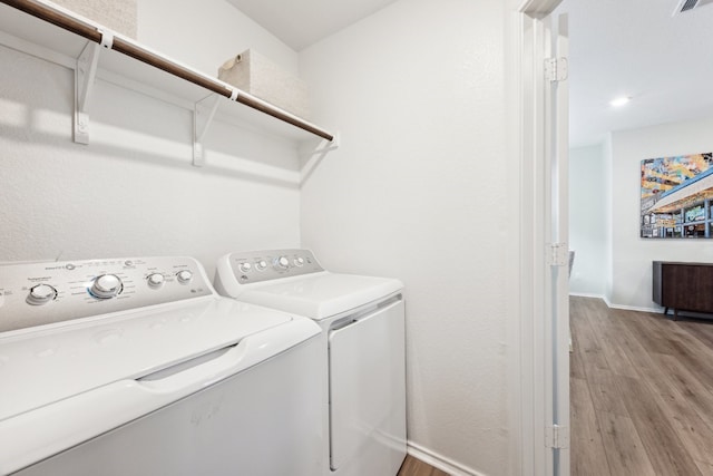 laundry area featuring washer and dryer and light wood-type flooring