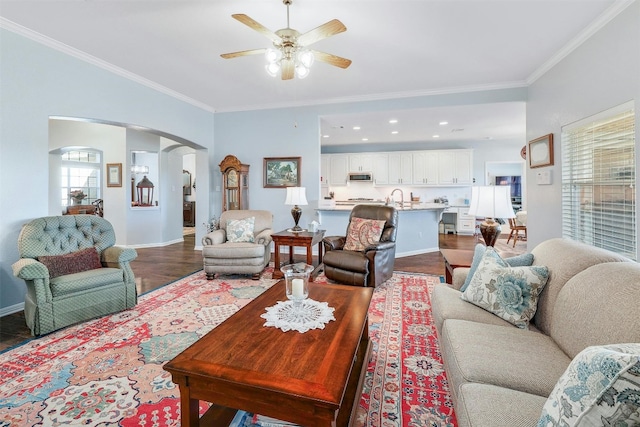 living room with ornamental molding, ceiling fan, hardwood / wood-style floors, and a wealth of natural light