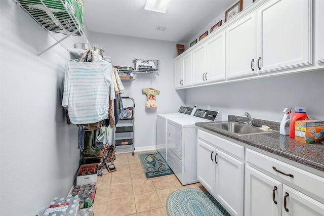 laundry area with light tile patterned floors, sink, separate washer and dryer, and cabinets