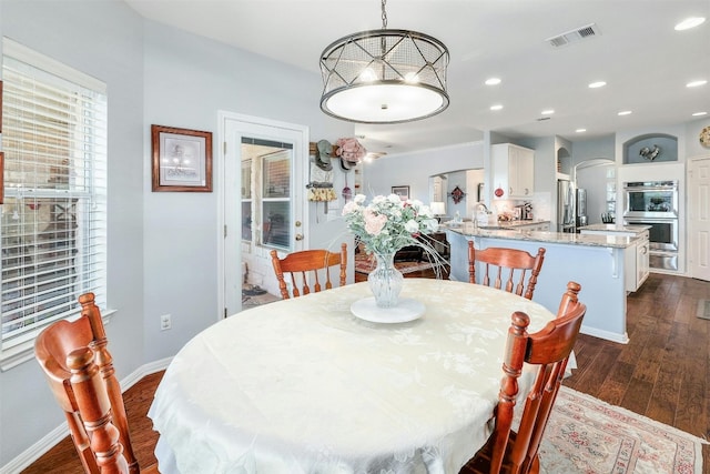 dining area featuring sink and dark hardwood / wood-style flooring