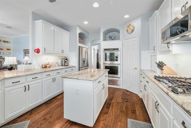 kitchen with white cabinets, stainless steel appliances, and dark hardwood / wood-style floors