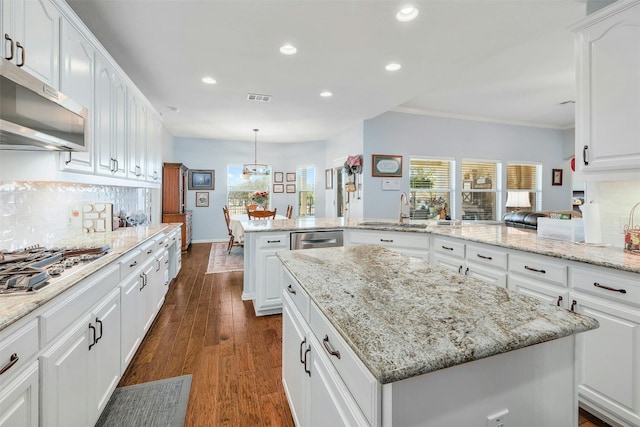 kitchen with dark hardwood / wood-style flooring, white cabinets, sink, and a kitchen island