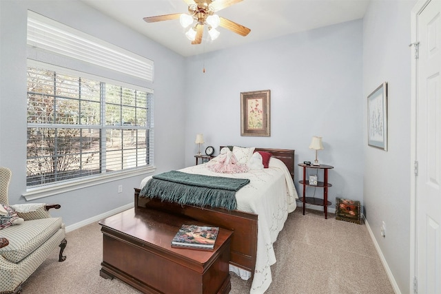 bedroom featuring ceiling fan, light carpet, and multiple windows