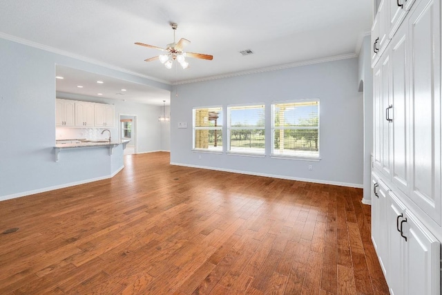 1900 County Road 245, Georgetown, TX 78633 - unfurnished living room featuring a ceiling fan, wood finished floors, crown molding, and recessed lighting