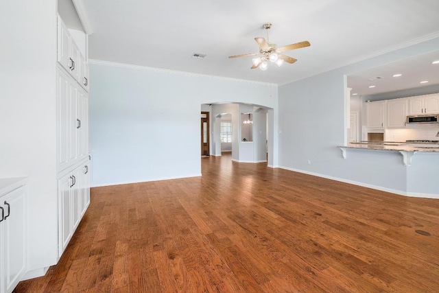 1900 County Road 245, Georgetown, TX 78633 - unfurnished living room featuring ceiling fan, arched walkways, ornamental molding, wood finished floors, and recessed lighting