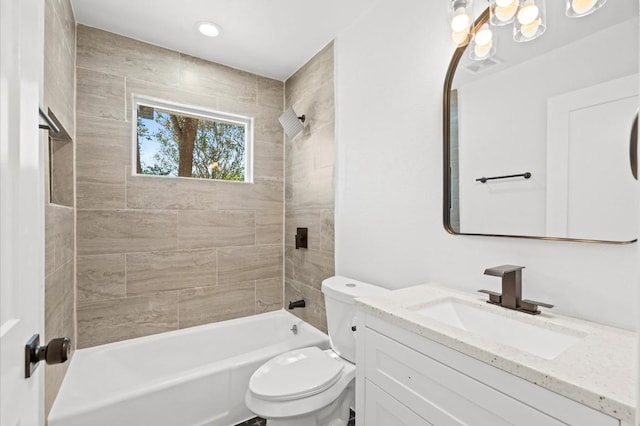 full bathroom featuring toilet, vanity, and tiled shower / bath