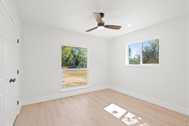 spare room with ceiling fan and light wood-type flooring