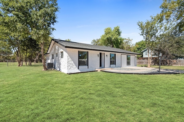 view of front of property with central AC unit, a patio, and a front lawn