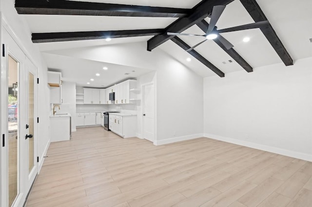 unfurnished living room with light hardwood / wood-style flooring, lofted ceiling with beams, and sink