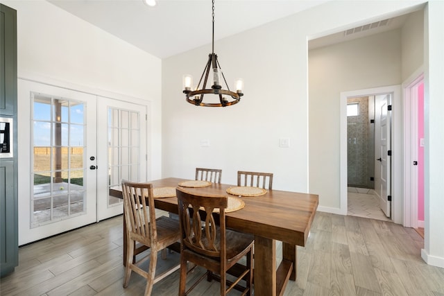 dining area featuring a chandelier, french doors, and light hardwood / wood-style floors