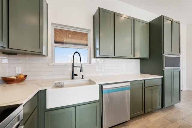 kitchen with decorative backsplash, green cabinetry, and stainless steel dishwasher