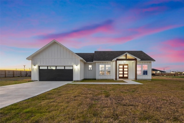 modern farmhouse style home featuring a garage and a lawn