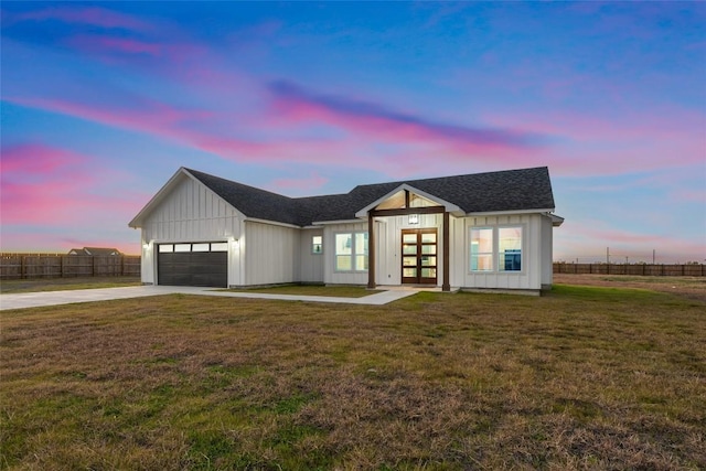 modern inspired farmhouse featuring a garage, a yard, and french doors