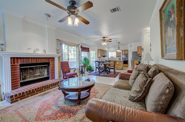 tiled living room featuring crown molding, a brick fireplace, and ceiling fan