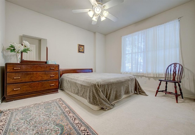 bedroom featuring light carpet, baseboards, and a ceiling fan