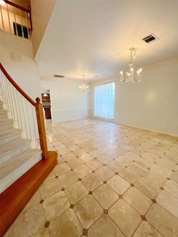 11205 Appletree Ln, Austin, TX 78726 - spare room with a chandelier, ornamental molding, a decorative wall, stairway, and a wainscoted wall