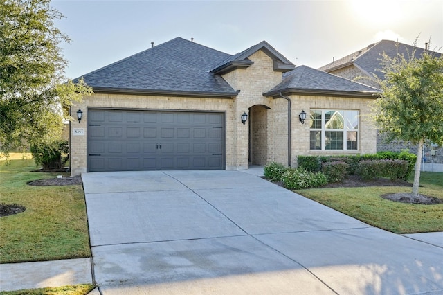 view of front of house featuring a front lawn and a garage