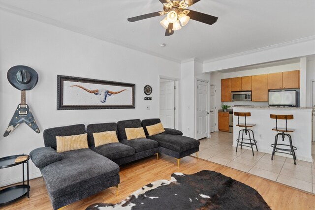 tiled living room featuring crown molding and ceiling fan