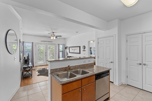 kitchen featuring ceiling fan, light tile patterned floors, an island with sink, dishwasher, and sink