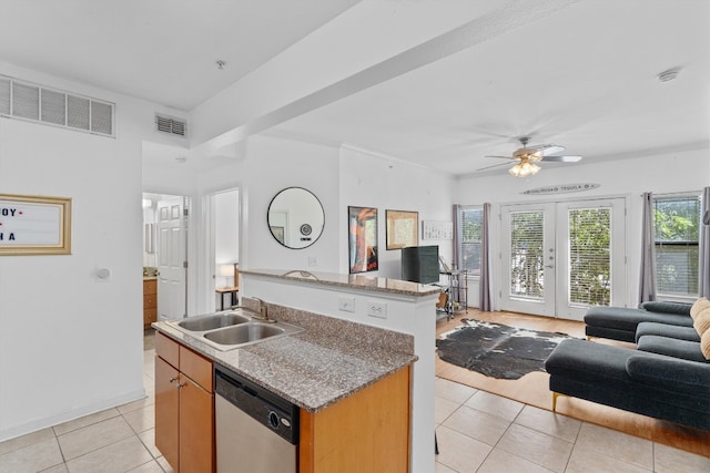 kitchen with a center island with sink, ceiling fan, light tile patterned floors, dishwasher, and sink