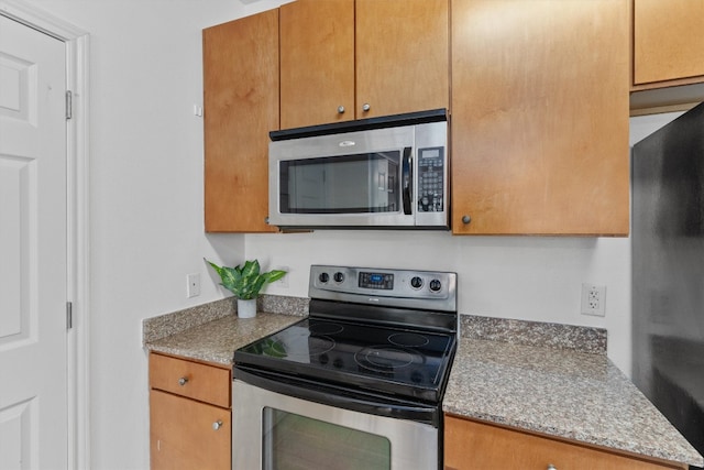 kitchen with stone counters and appliances with stainless steel finishes