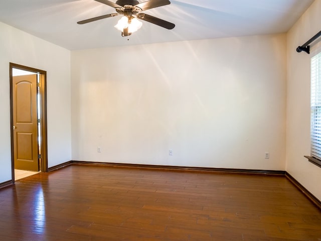 empty room with dark hardwood / wood-style floors and ceiling fan