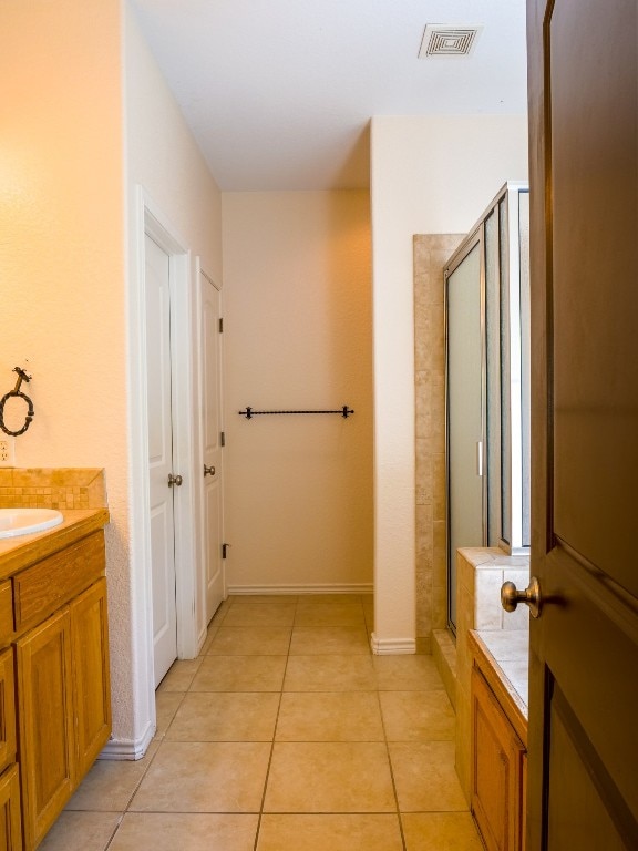 bathroom featuring vanity, walk in shower, and tile patterned flooring