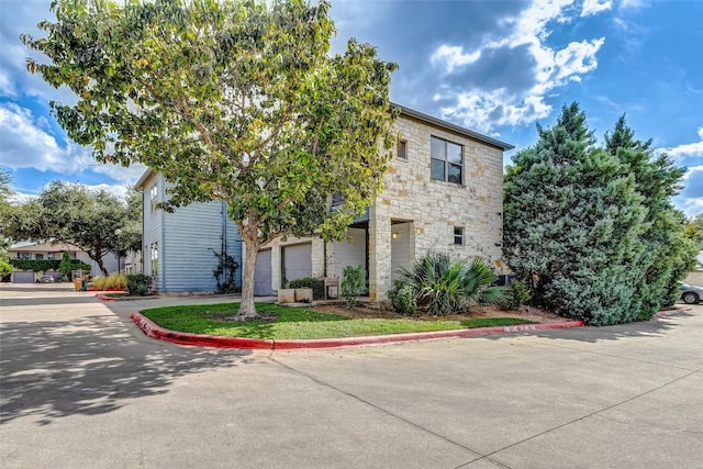 1201 Grove Blvd Unit 2403, Austin, TX 78741 - view of front of home featuring stone siding, an attached garage, and concrete driveway