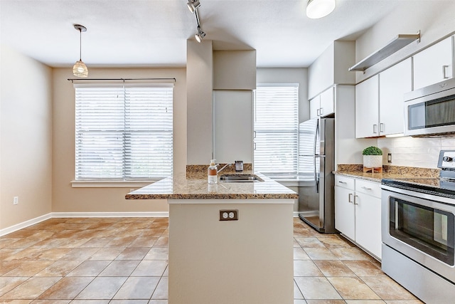 kitchen featuring sink, kitchen peninsula, stainless steel appliances, pendant lighting, and white cabinets