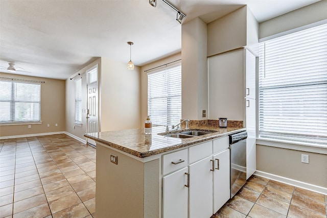 kitchen with white cabinets, a healthy amount of sunlight, stainless steel dishwasher, and pendant lighting