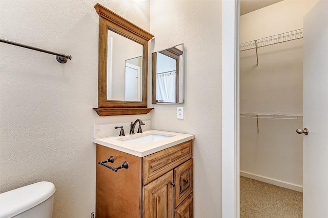 1201 Grove Blvd Unit 2403, Austin, TX 78741 - bathroom featuring vanity, a spacious closet, and toilet