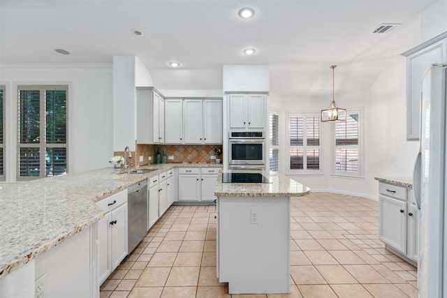 kitchen with pendant lighting, sink, decorative backsplash, light stone countertops, and appliances with stainless steel finishes