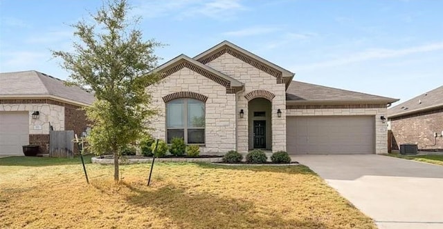 view of front of property with central air condition unit, a front lawn, and a garage