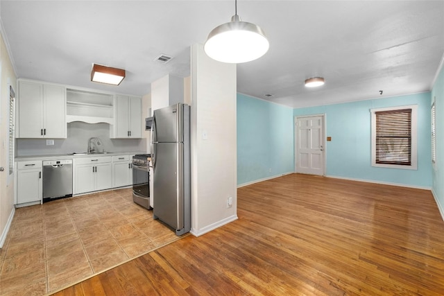 kitchen featuring white cabinets, hanging light fixtures, appliances with stainless steel finishes, light wood-type flooring, and sink